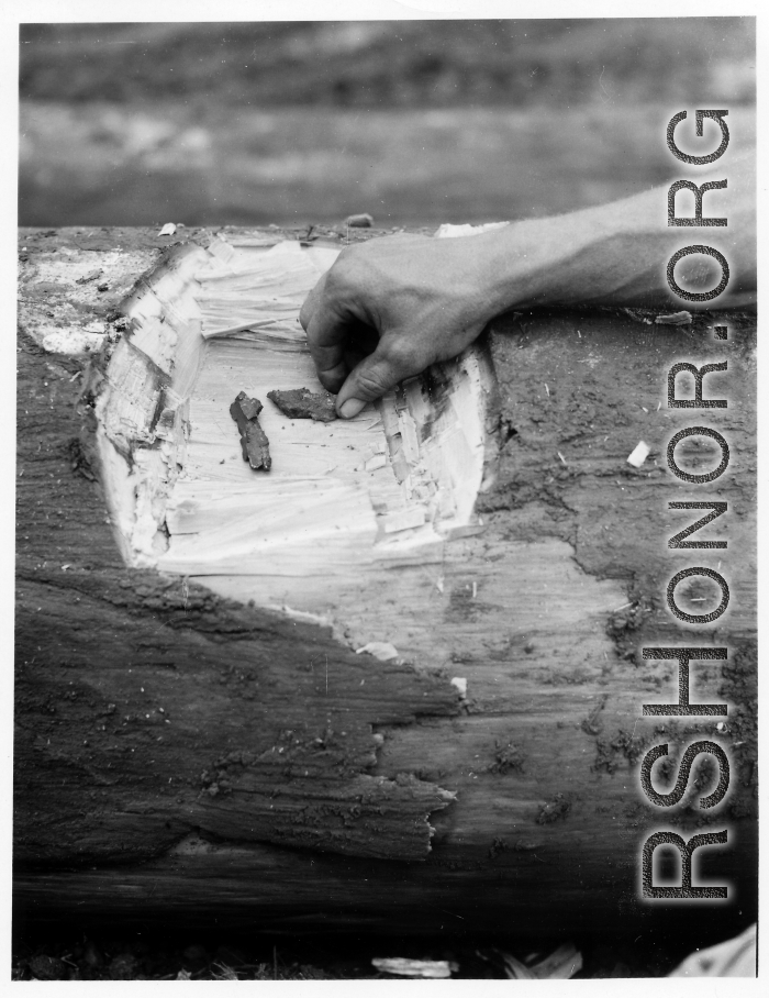 GIs collect shrapnel from bomb explosion in Burma.  During WWII.  797th Engineer Forestry Company.