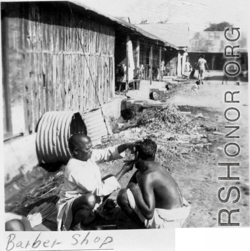 A little roadside barbering in the CBI, either Burma or India.