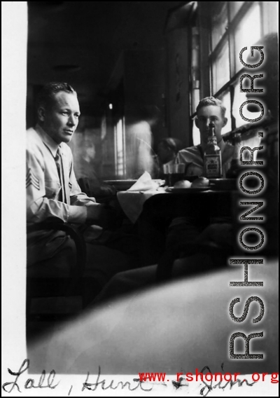 Everett Lull, Paul Hunt, and James Vaughn relaxing over a few drinks and food in the CBI, most likely on or near an American air base in China, during WWII.