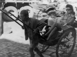 Wealthy woman rides rickshaw in China during WWII.