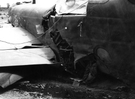 Wrecked B-25 Mitchell bomber on the ground in the CBI. The wreck was apparently at an air base, and probably on take-off, as the craft is sprayed with fire-retardant foam, and bombs are scattered about the wreck site. During WWII.