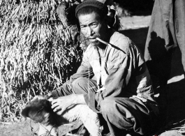 Local farmer in China, in Yunnan province, near Yangkai, with a small dog. During WWII.