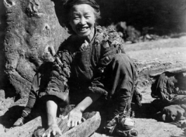 Woman washes clothing in wood trough. In Yunnan, China, during WWII.