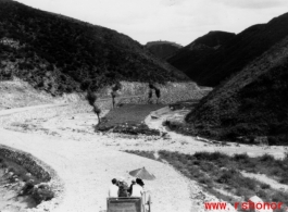 A simple vehicle passes along a newly cut road in SW China during WWII.