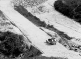 A vehicle passes along a newly cut road in SW China during WWII.