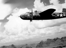 B-25 Mitchell bomber surges forward in flight over limestone karst mountains, in the area of southern China, Indochina, or Burma.