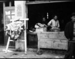 Butcher shop with fresh meat hung to carve in China during WWII.