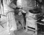 "This Chinese vendor located his 'place of business' along the road from Kunming to Chengdu. He was selling small nuts that were deep fried. An American convoy stopped in this area and an American soldier took advantage of the time to make a purchase."
