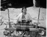 Local people in Burma near the 797th Engineer Forestry Company--A woman weaves on a loom in Burma.  During WWII.