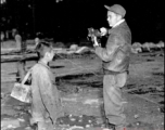 16th Combat Camera Unit photographer Hal Geer takes pictures in China during WWII. The person with him might be an assistant.