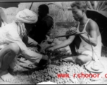 Measuring produce at farmer's market, Misamari, India, during WWII.