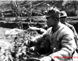 Chinese soldiers riding a motorized vehicle during exercises in southern China, probably Yunnan province, or possibly in Burma, riding a motorcycle.